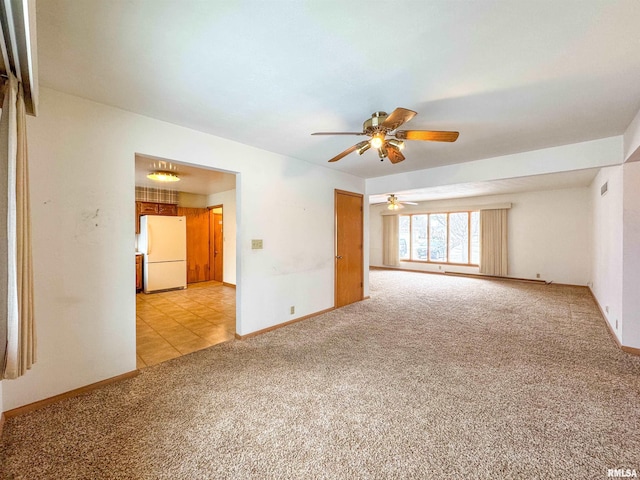 empty room with ceiling fan and light carpet