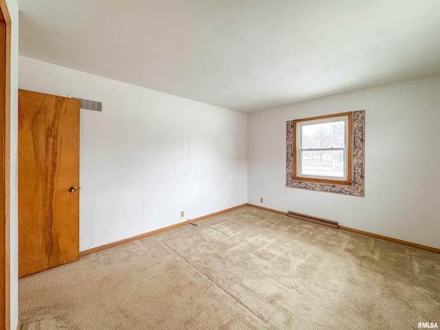 empty room featuring carpet and a baseboard heating unit