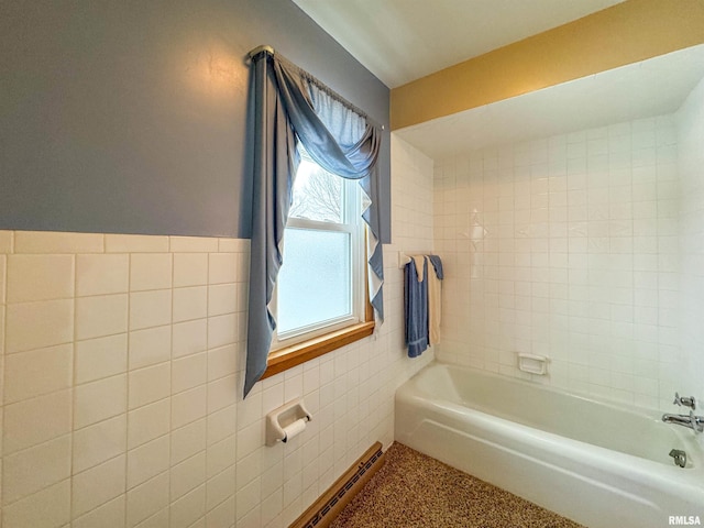 bathroom featuring a washtub and tile walls