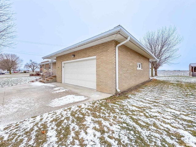 view of snow covered exterior featuring a garage