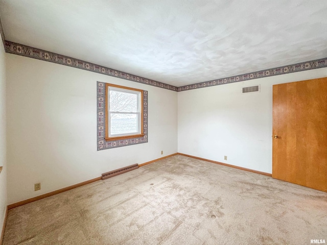 unfurnished room with carpet flooring and baseboard heating