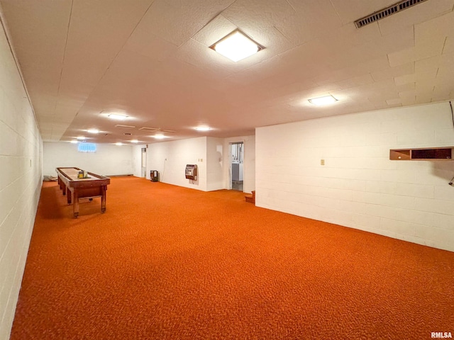 basement featuring heating unit and carpet