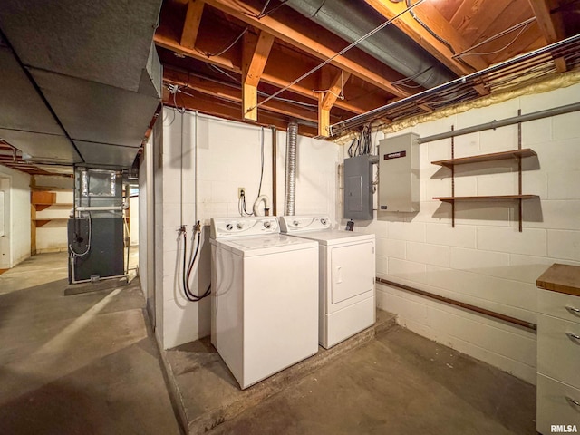 basement with electric panel, washer and clothes dryer, and heating unit