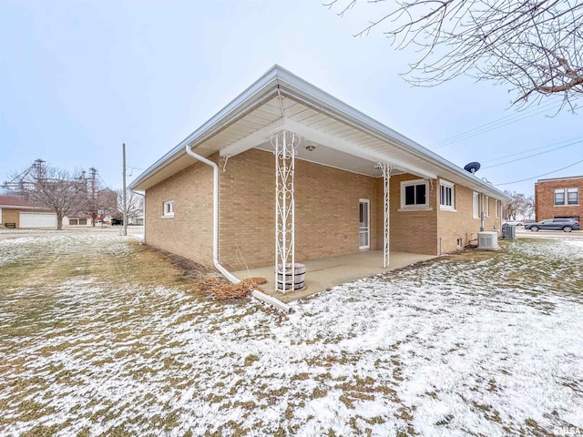 snow covered rear of property with cooling unit