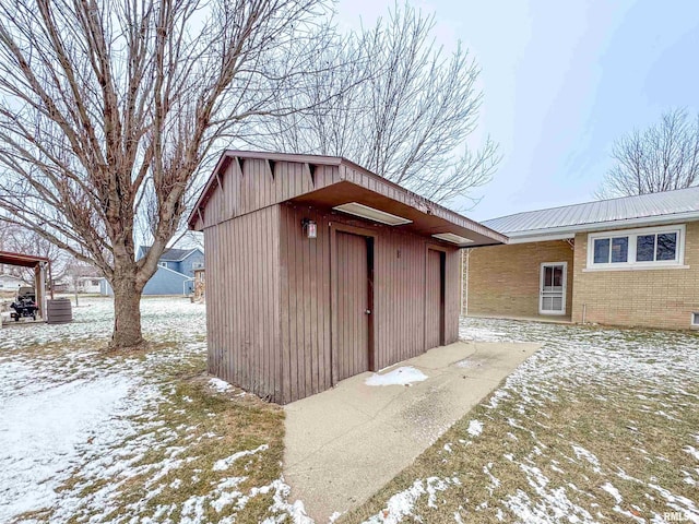 snow covered structure featuring central AC unit