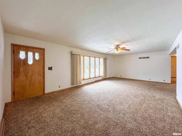 foyer entrance featuring ceiling fan and carpet floors