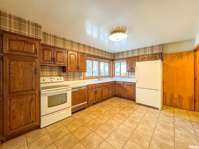 kitchen featuring light tile patterned floors, white appliances, tasteful backsplash, and sink