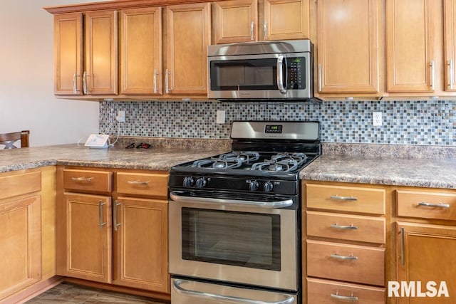 kitchen with decorative backsplash and appliances with stainless steel finishes