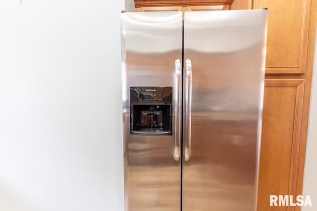 room details with stainless steel fridge and light brown cabinets