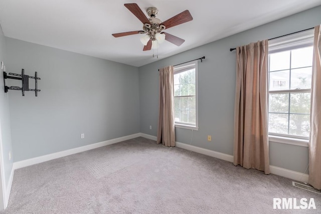 carpeted spare room featuring ceiling fan