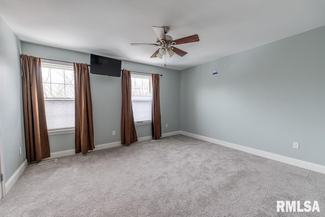 unfurnished room with carpet flooring, a wealth of natural light, and ceiling fan