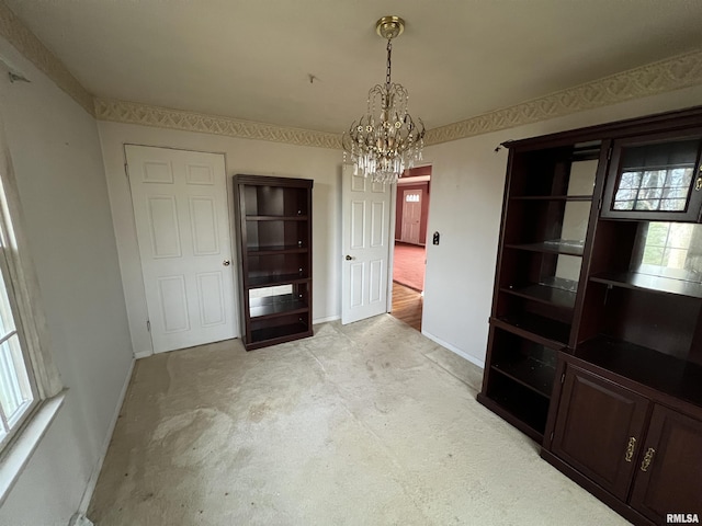 unfurnished dining area with a notable chandelier and light colored carpet