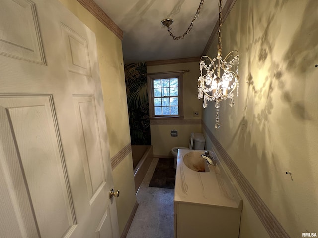 bathroom with vanity, toilet, ornamental molding, and a chandelier