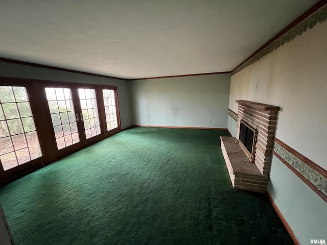 unfurnished living room featuring crown molding, a fireplace, dark carpet, and french doors