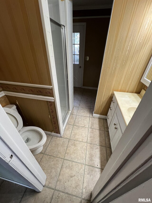 bathroom with tile patterned floors, an enclosed shower, ornamental molding, vanity, and wood walls