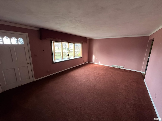 carpeted foyer entrance with a textured ceiling and crown molding