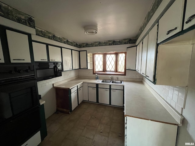 kitchen featuring decorative backsplash, sink, and black appliances