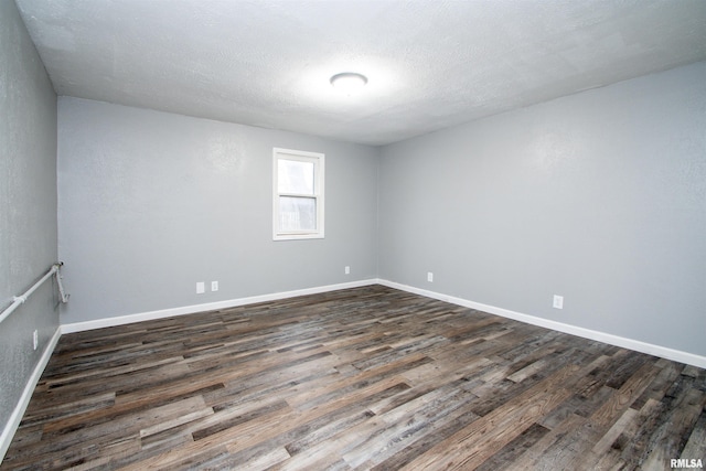 unfurnished room with a textured ceiling and dark wood-type flooring