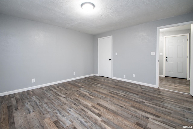 empty room featuring dark hardwood / wood-style flooring and a textured ceiling