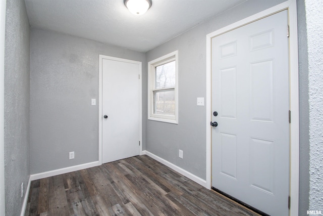 entrance foyer with dark hardwood / wood-style floors and a textured ceiling