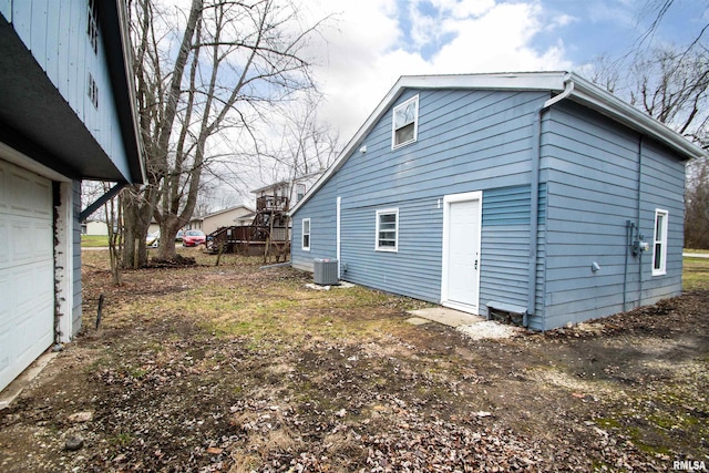 view of property exterior with central air condition unit and a garage