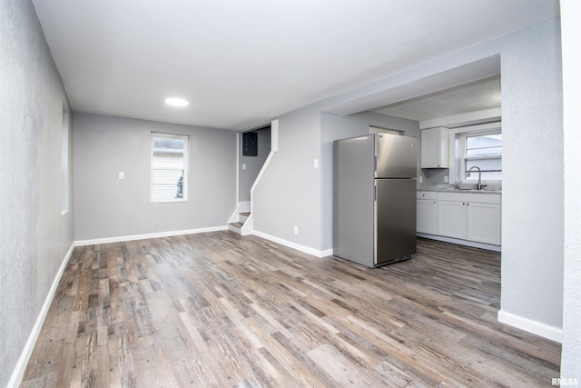 unfurnished living room with hardwood / wood-style floors and sink