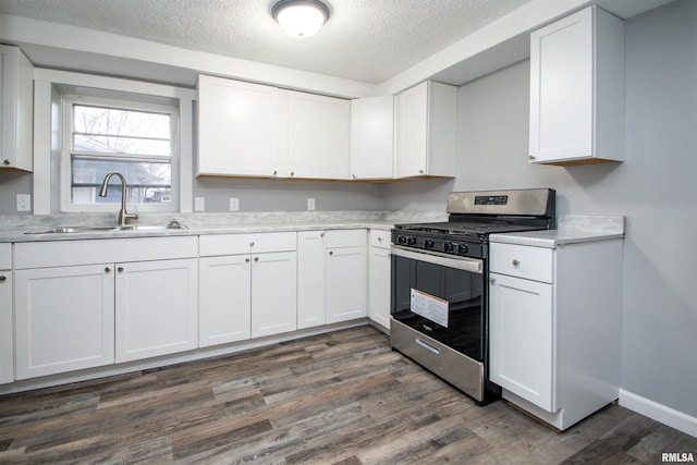 kitchen with white cabinets, gas stove, dark hardwood / wood-style flooring, and sink