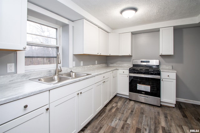 kitchen featuring sink, stainless steel gas range, dark hardwood / wood-style floors, a textured ceiling, and white cabinets