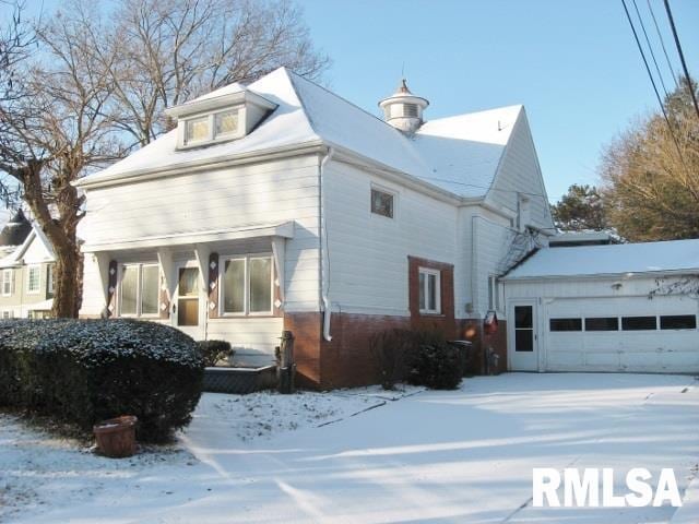 snow covered property with a garage