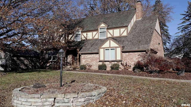 tudor-style house featuring a front lawn