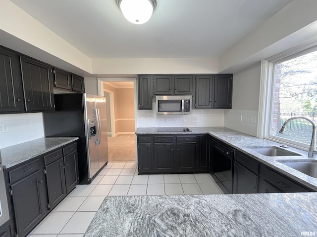 kitchen with light stone countertops, sink, backsplash, light tile patterned floors, and black appliances