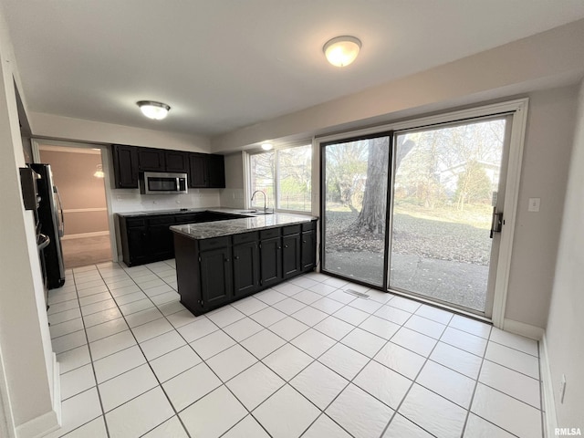 kitchen featuring sink, light tile patterned floors, and stainless steel appliances