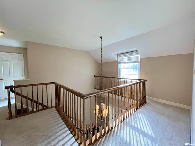 hallway featuring carpet flooring and lofted ceiling