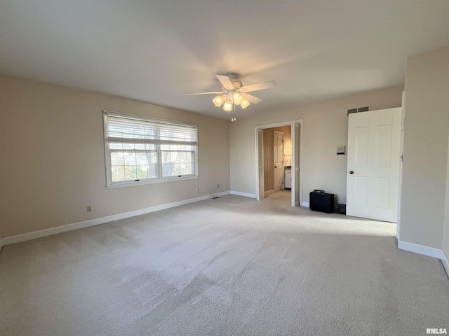 carpeted spare room featuring ceiling fan