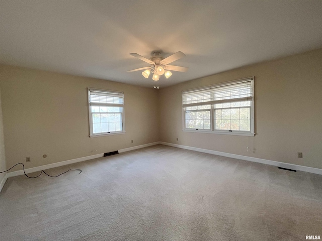 carpeted spare room with ceiling fan