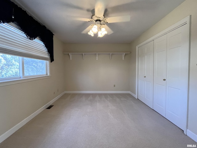 unfurnished bedroom with ceiling fan, a closet, and light colored carpet