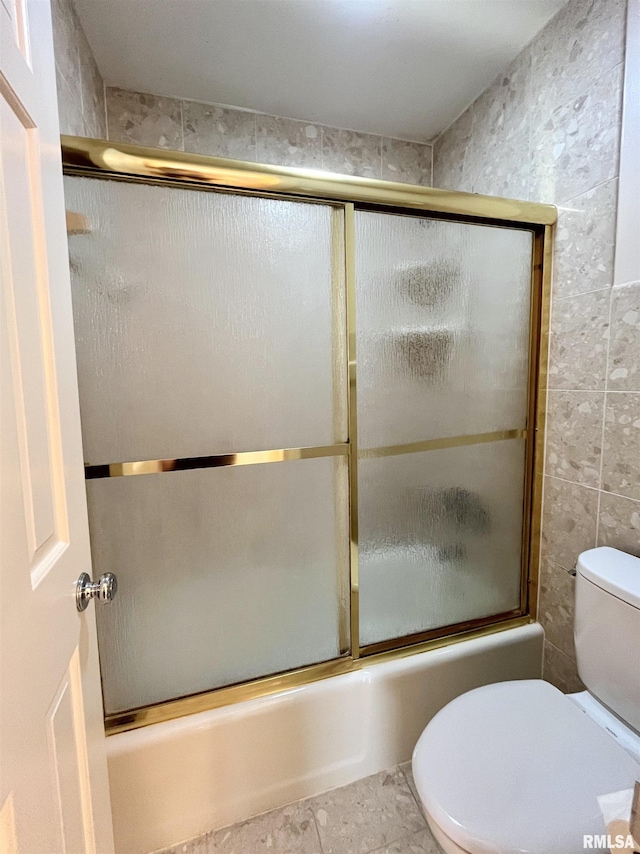 bathroom with toilet, tile patterned floors, tile walls, and enclosed tub / shower combo