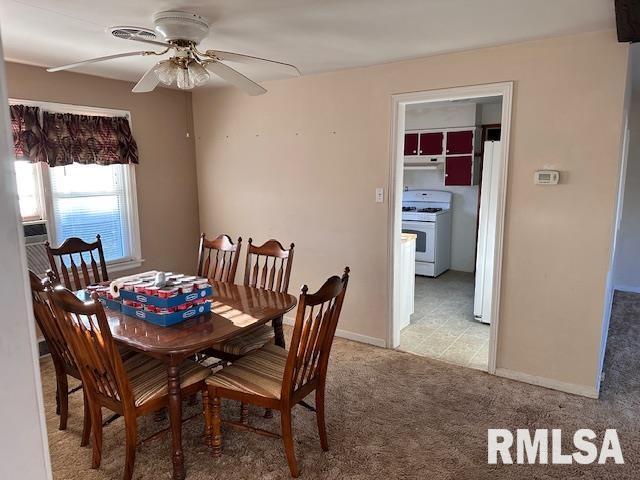 carpeted dining area with ceiling fan