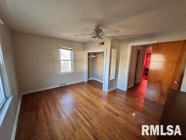 unfurnished bedroom with ceiling fan, dark wood-type flooring, and a closet