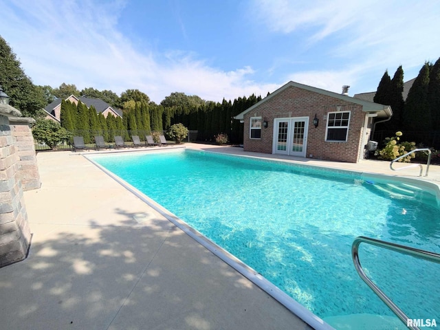 view of pool featuring french doors, an outbuilding, and a patio