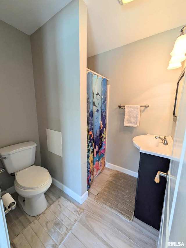 bathroom featuring curtained shower, toilet, vanity, and hardwood / wood-style flooring