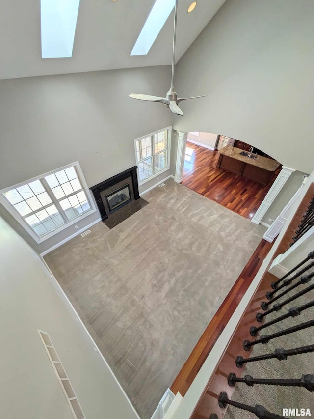 living room featuring ceiling fan, high vaulted ceiling, and wood-type flooring