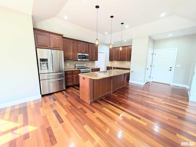 kitchen featuring dark wood-type flooring, sink, decorative backsplash, light stone countertops, and appliances with stainless steel finishes