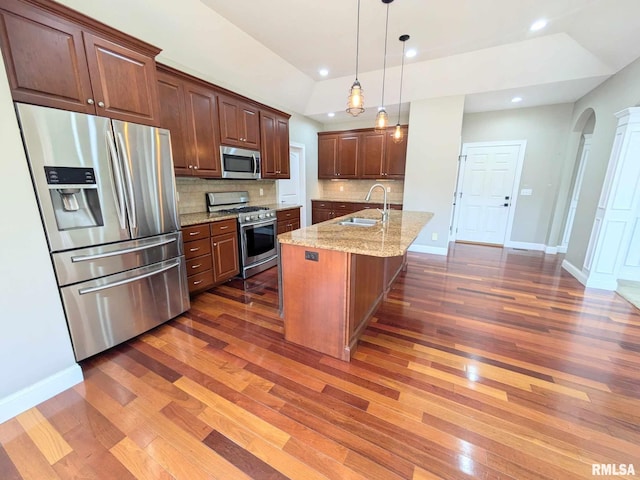 kitchen featuring appliances with stainless steel finishes, a kitchen island with sink, dark wood-type flooring, and sink