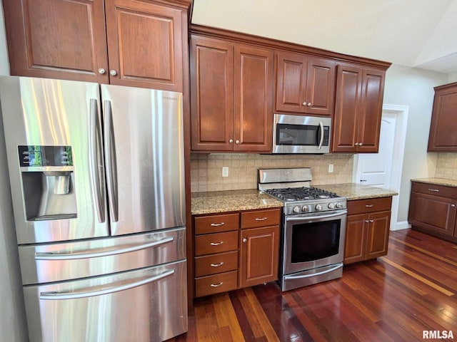 kitchen featuring backsplash, light stone countertops, dark wood-type flooring, and stainless steel appliances