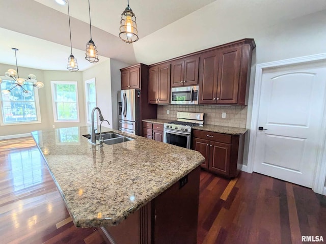 kitchen with pendant lighting, sink, dark hardwood / wood-style floors, an island with sink, and stainless steel appliances