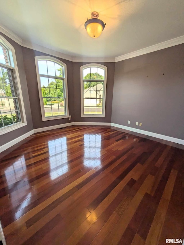 spare room featuring crown molding and dark wood-type flooring