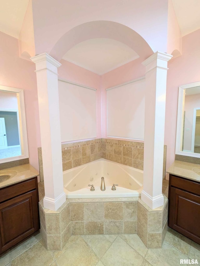 bathroom featuring tiled bath, vanity, decorative columns, and tile patterned flooring