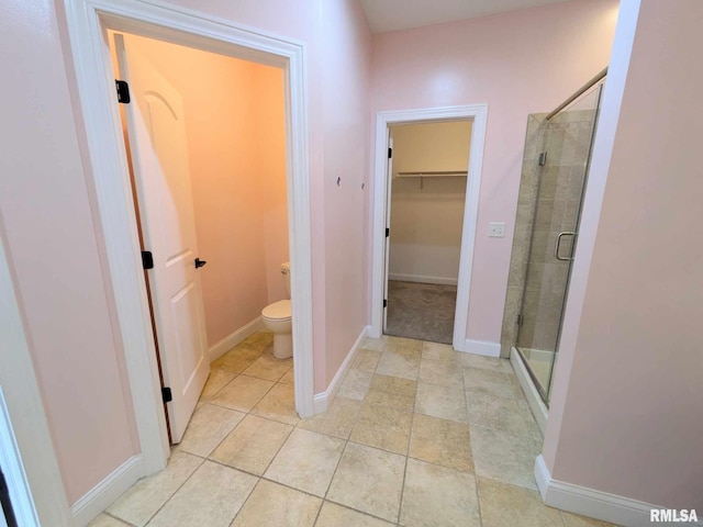 bathroom with tile patterned flooring, toilet, and walk in shower