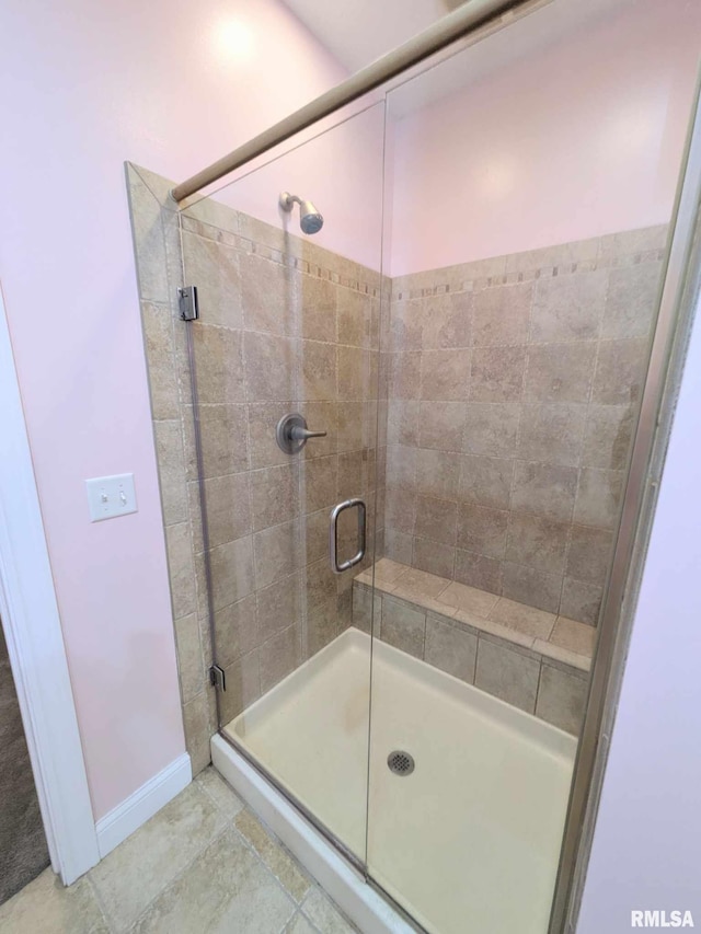 bathroom featuring tile patterned floors and a shower with shower door